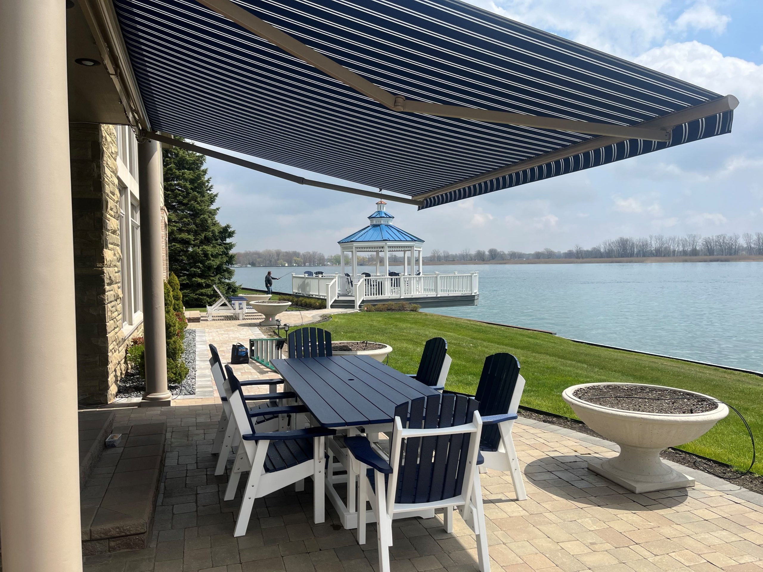 Home next to water with awning extended over back patio area