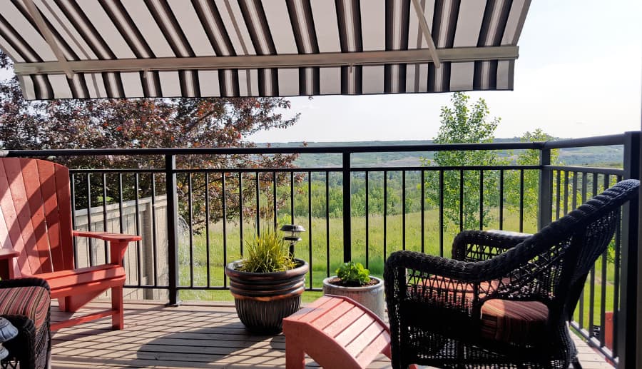 Retractable awning shading deck with patio furniture from sun